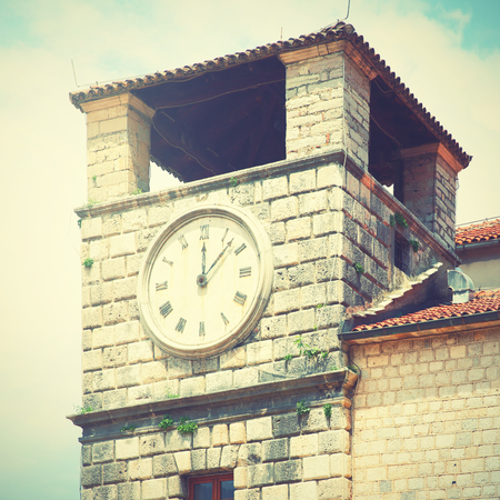 Clock tower in Old town of Kotor, Montenegro. Retro style filtered image