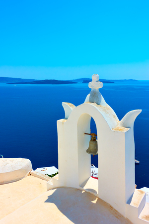 White belfry of greek orthodox church in Oia in Santorini, Greece - Landscape, space for textの写真素材