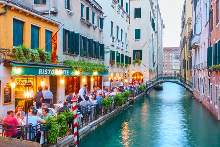 Venice, Italy - June 14, 2018: People at restaurant with tables outdoors near small canal in Veniceのeditorial素材