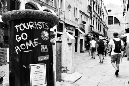 Venice, Italy - June 18, 2018: "Tourists go home" graffito over litterbin in Veniceのeditorial素材