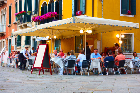 Venice, Italy - June 14, 2018: People at cafe - pizzeria with tables in the open air in Veniceのeditorial素材