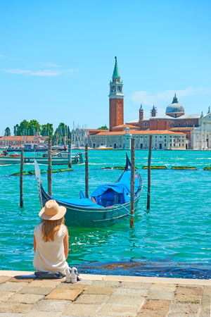 Venice, Italy - June 15, 2018: An unidentified woman with sunhut at quayside in Veniceのeditorial素材