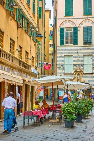 Genoa, Italy - July 06, 2019: Old street in Genoa and people in cafeのeditorial素材