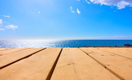 Wooden table and blue sea in the background. Mock up templateの写真素材