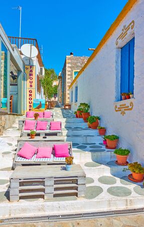 Perdika, Aegina Island, Greece  - September 14, 2019:  Open-air restaurant at with couches in the street in Perdikaのeditorial素材
