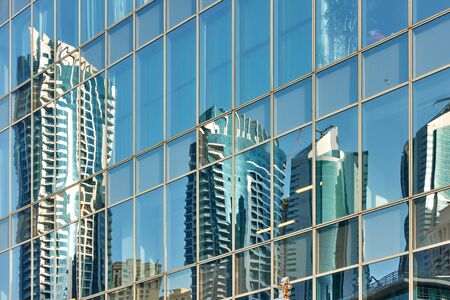 Reflection of skyscrapers in the glass wall of modern tower -  architectural backgroundの写真素材