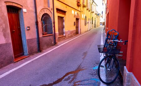Perspective of street and bicycle near wall in Rimini, Italy. Italian cityscape, wide angle shot