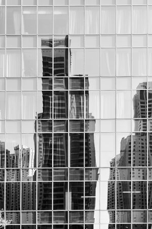 Reflection of towers in the glass wall of a buildingの写真素材