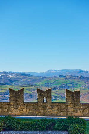 Pinion city wall of San Marino, mountains in the background and clear blue sky with space for your own textのeditorial素材