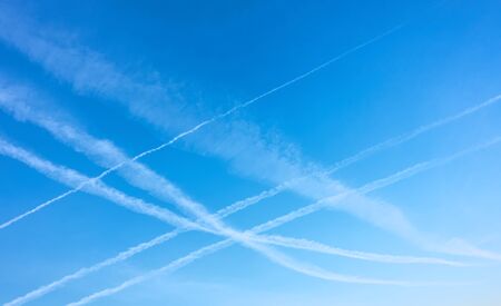 Blue clear sky with plane exhausts, may be used as background