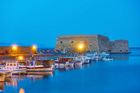 Fishing boats near the Koules Fortress in Heraklion at twilight, Crete island, Greeceのeditorial素材