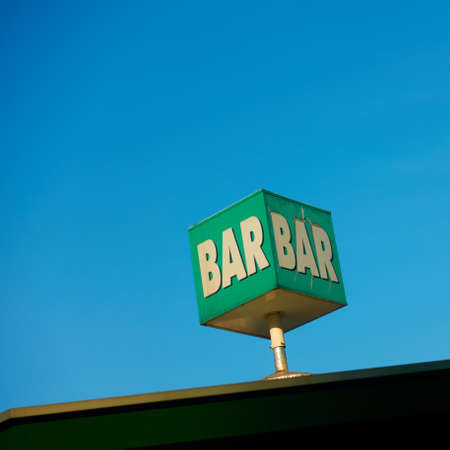 Bar sign on the roof against the blue sky. Space for your own textの写真素材