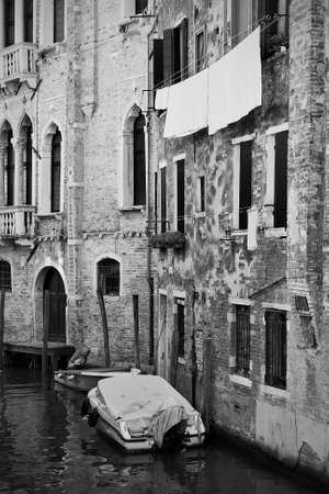 Venetian canal with old houses  and moored boats, Venice, Italy. Black and white photography, cityscapeの写真素材