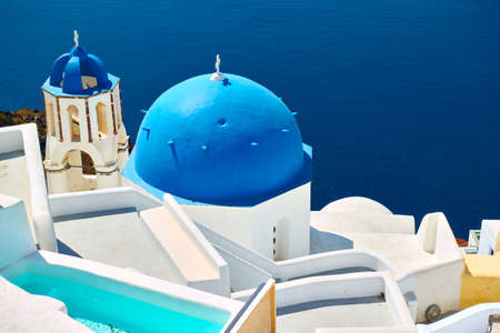 Santorini island in Greece. Sea and greek church with blue dome and bell towerの写真素材