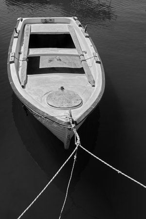 Moored old wooden oar boat. Black and white photographyの写真素材