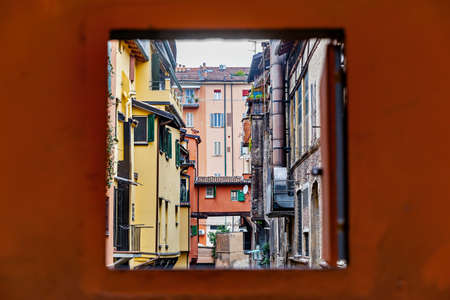 Secret window in the wall to the hidden part of the city in Bologna, Italy. Canal of Reno in Piella streetの写真素材