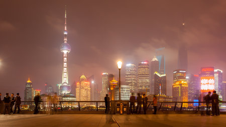 Shanghai, China - April 11, 2014: People on The Bund waterfront watching panoramic view of Shanghai city at nightのeditorial素材