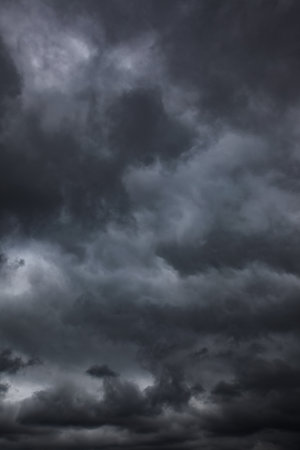 Dramatic sky with black stormy clouds, may be used as backgroundの写真素材