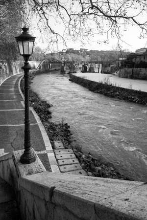 River bank of The Tiber with vintage street light, Rome, Italy. Black and white photographyの写真素材