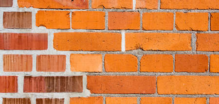 Texture of red brick wall of bricks of different tint, may be used as backgroundの写真素材