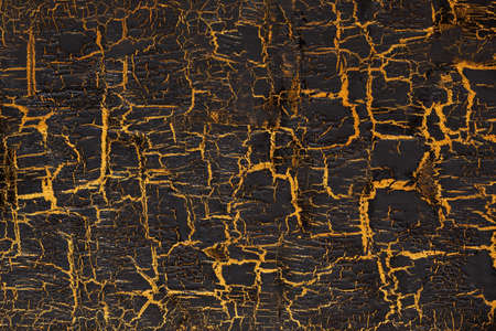 Black paint with gold crackles, may be used as backgroundの写真素材