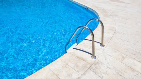Swimming pool with stairs and clear blue water