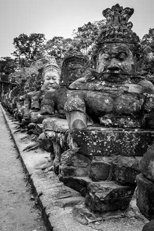 Figures on the bridge - Ancient khmer statues in Angkor, Cambodia. Black and whiteの写真素材