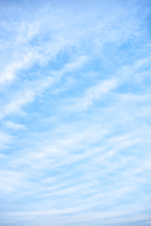 Light-blue sky with white clouds - vertical backgroundの写真素材