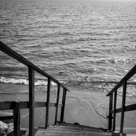 Sea and steep stairs to the beach. Black and white photographyの写真素材