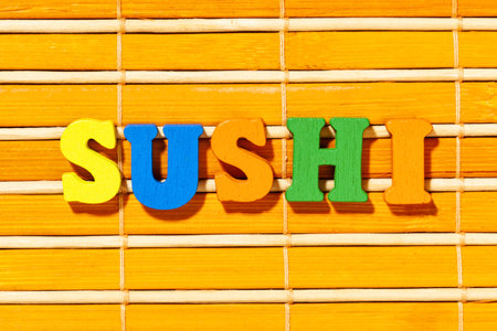 Sushi word - Inscription by colorful letters on bamboo matの写真素材