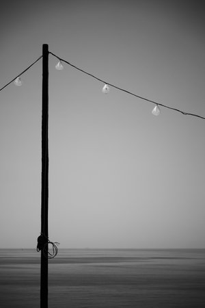 Holidays Is Over - Turned off holiday lights by the sea. Minimal black and white landscapeの写真素材