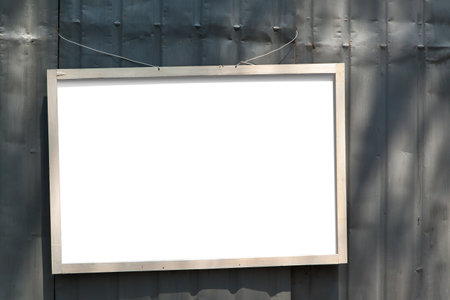 Frame mockup. Simple wooden frame on metal fence outdoorの写真素材