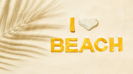 I Love Beach - Golden letters in the sand and shadow of palm leafの写真素材