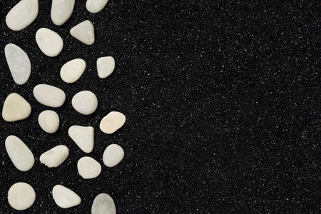 Black sand with pebbles. Beach background with space for your own textの写真素材