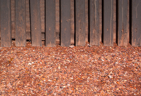 red crushed gravel with wood wall background and textureの写真素材