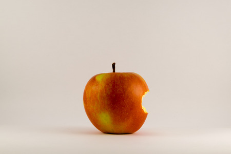 Bitten red apple on a white background.の写真素材