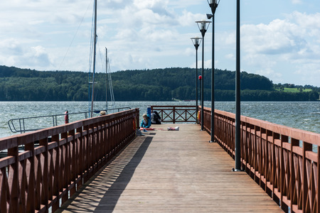A pier into a calm blue lake.の写真素材