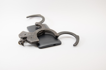 unlocked phone. phone with unlocked handcuffs on white background.の写真素材