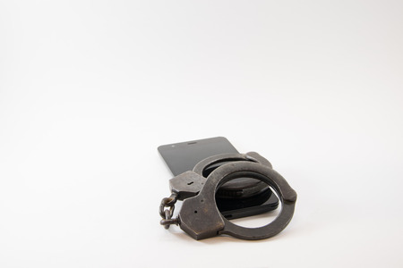locked phone. phone locked with handcuffs on white background.の写真素材