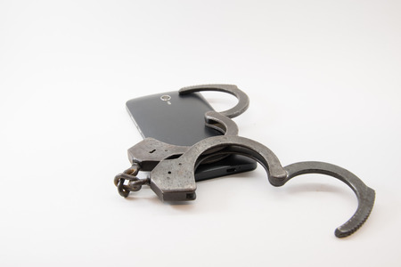 unlocked phone. phone with unlocked handcuffs on white background.の写真素材