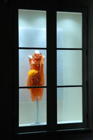Single red dress displayed in store window