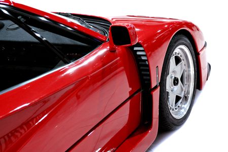 The side and front end of a red sports car
