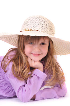 beautiful little girl with long hair and a hat on a white backgroundの写真素材