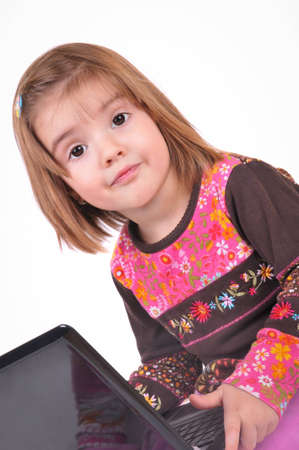 Beautiful little girl with laptop on the white backgroundsの写真素材