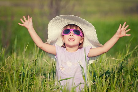 A beautiful little girl with a hat in a grain fieldの写真素材