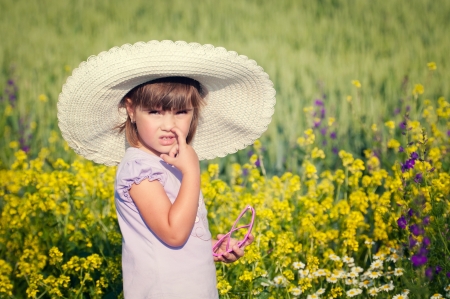 Little girl smelling flowers in a gardenの写真素材