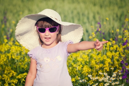 Little girl smelling flowers in a gardenの写真素材