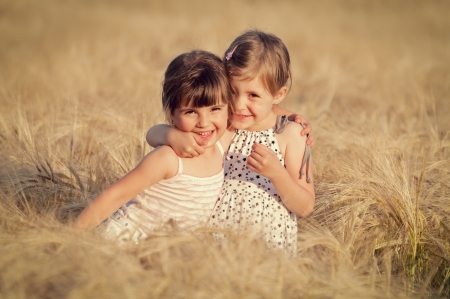 Happy girl in the field of wheat on sunny dayの写真素材
