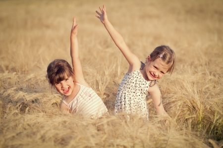 Happy girl in the field of wheat on sunny dayの写真素材