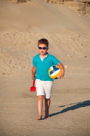 Little boy playing on the sandy beachの写真素材